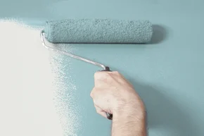 Verarbeitung - Person, die Malerei einer Wand blaues mit einem Farbroller - Stock-Fotografie
