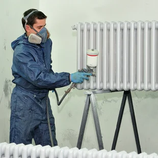 Heizkörper renovieren - Arbeiter in einer Farbe Stand. - Stock-Fotografie